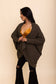 a young brunette woman wearing black jeans and an olive green batwing cardigan.

